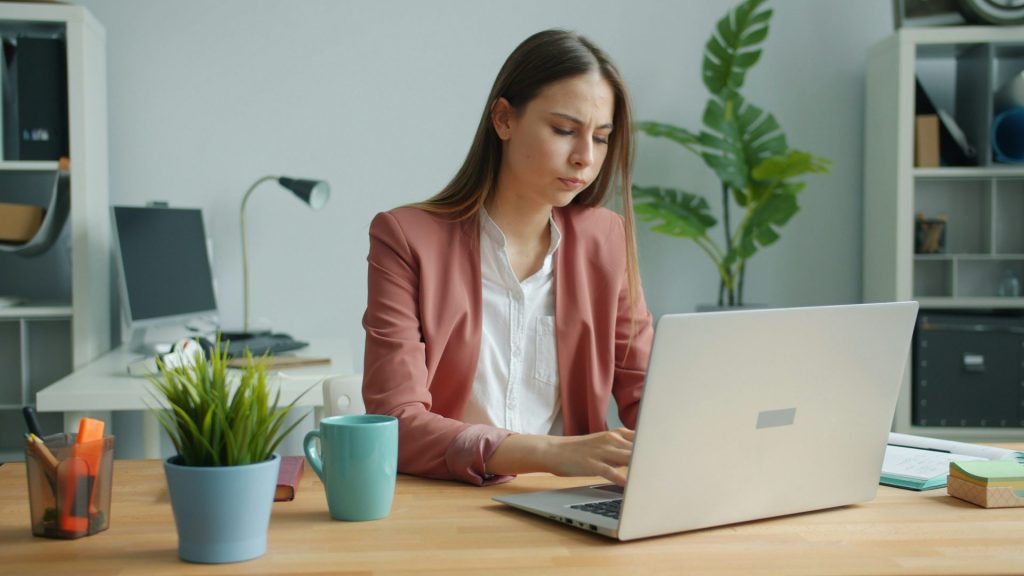Jeune femme travaillant sur un ordinateur portable à un bureau.